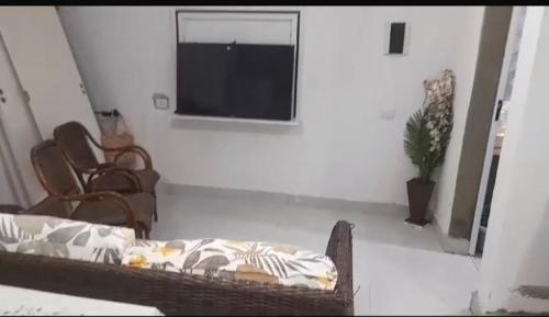 un salon avec une télévision à écran plat sur un mur dans l'établissement Casa de praia itanhaem, à Itanhaém