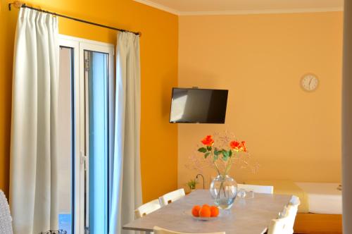 a dining room with a table with a vase of flowers at Villa Reverenza in Lixouri