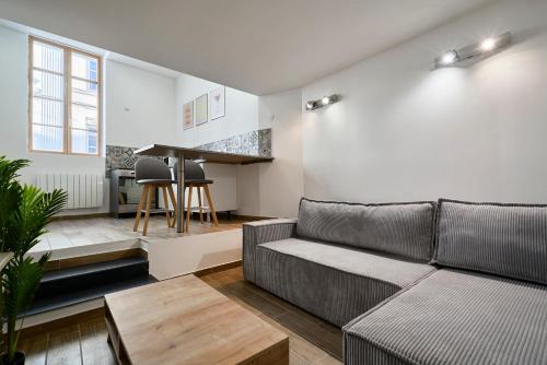 un salon avec un canapé et une table dans l'établissement Charmante maison pour 4 au cœur de Valenciennes, à Valenciennes