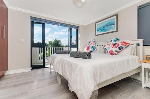 a bedroom with a bed and a large window at Tranquil Lagoon Loft in Knysna