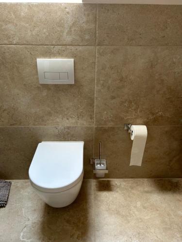 a bathroom with a toilet and a roll of toilet paper at Appartment an der König Ludwig Promenade in Füssen
