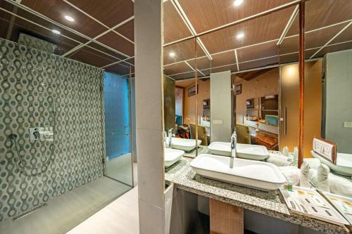 a bathroom with four sinks and a shower at Aamari Resort in Rāmgarh