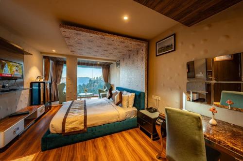 a bedroom with a bed and a desk and a television at Aamari Resort in Rāmgarh