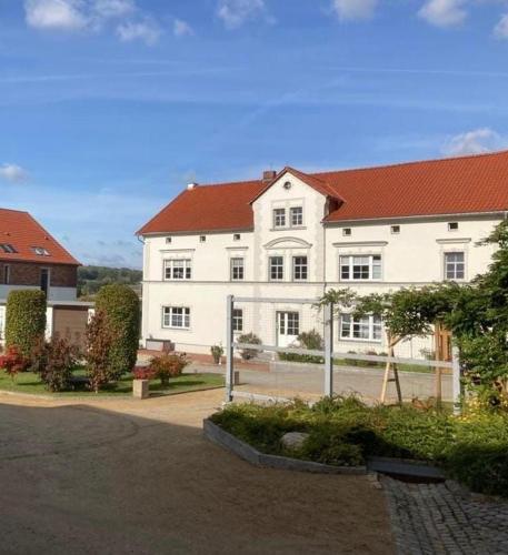 a large white building with a red roof at Ferienwohnung Schöpstalblick in Ebersbach