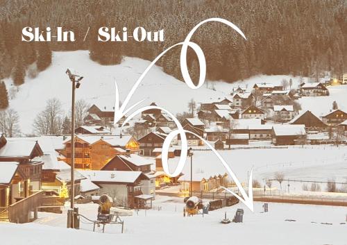 a snow covered town with the olympic rings in the foreground at SEIN Boutique Suites - ADULTS ONLY in Gosau