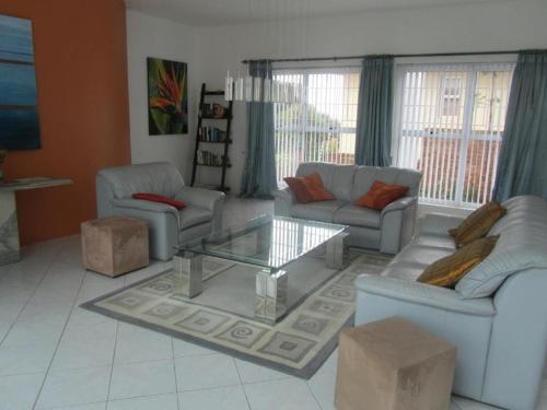 a living room with couches and a coffee table at Villa De Mer in Port Alfred