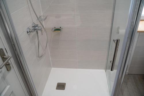 a shower with a glass door in a bathroom at Studio tout équipé in Vaugneray