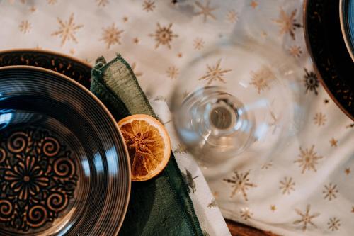 a plate with an orange slice next to a glass at Legenda Lasu - drewniany domek w górach z jacuzzi, przy stoku narciarskim Kotelnica, Białka Tatrzańska, w pobliżu Term Bania in Groń