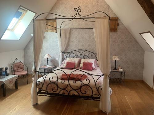 a bedroom with a canopy bed with pink pillows at Le Clos des Tilleuls D Day Home, Chambres d'hôtes, Suite avec Sauna Privatif, Suite avec balnéothérapie privative, en supplément option SPA bain à remous in La Vendelée