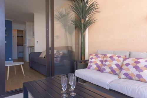 un salon avec un canapé et une table dans l'établissement L'AZUR avec terrasse vue mer, piscine accessible et près des plages, à Cannes