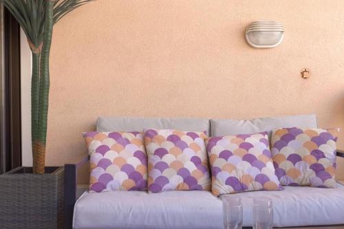 - un canapé bleu avec des oreillers en peluche à la polka dans l'établissement L'AZUR avec terrasse vue mer, piscine accessible et près des plages, à Cannes