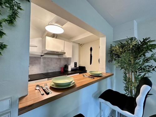 - une cuisine avec un comptoir en bois et des plats verts dans l'établissement Maison de Ville, à Angoulême