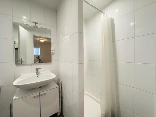 une salle de bain blanche avec un lavabo et un miroir dans l'établissement Maison de Ville, à Angoulême