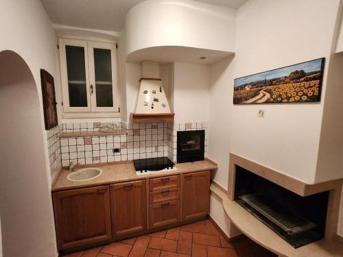 a kitchen with a sink and a fireplace at The courtyard of the 6 arches in Garlate