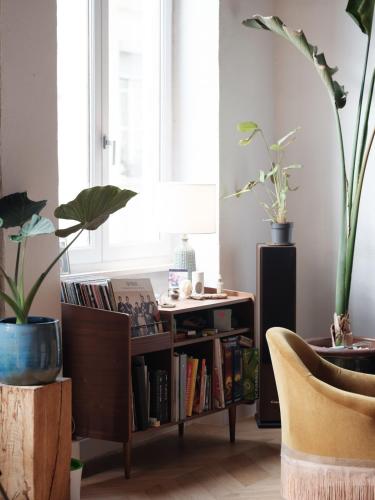 un salon avec des plantes et une étagère. dans l'établissement Le canut, à Lyon