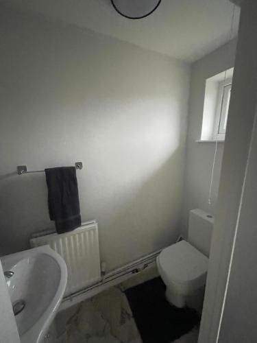 a bathroom with a white toilet and a sink at Spacious 3 Bedroom Home in Bletchley in Bletchley