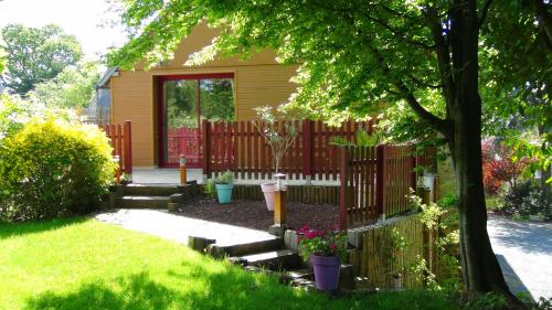 a garden with a fence and a house at Le Clos des Tilleuls D Day Home, Chambres d'hôtes, Suite avec Sauna Privatif, Suite avec balnéothérapie privative, en supplément option SPA bain à remous in La Vendelée