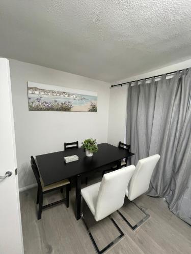 a dining room with a table and two white chairs at Spacious 3 Bedroom Home in Bletchley in Bletchley