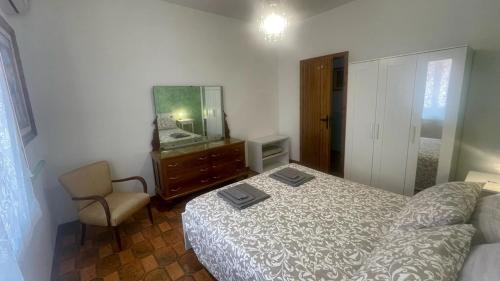 a bedroom with a bed and a mirror and a chair at Casa Romano - Marina di Modica in Marina di Modica