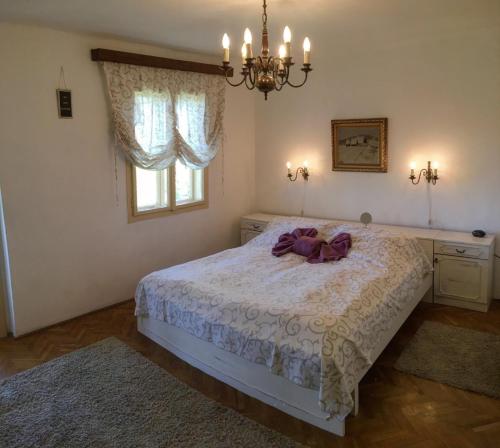 a bedroom with a bed with a purple bow on it at Villa Mila in Ludbreg