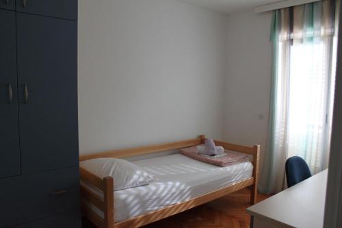 a small bedroom with a bed and a window at Spacious Green Home in Hvar