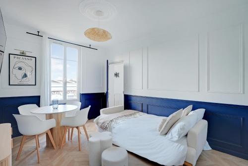 une chambre avec un lit, une table et des chaises dans l'établissement L'Azul - Entre Paris & Disney - Wifi, à Villemomble