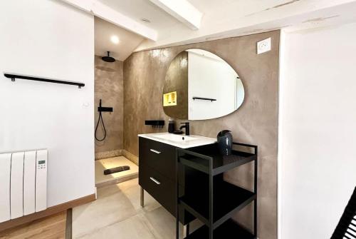 une salle de bain avec un lavabo et un miroir dans l'établissement Casamea - Vieille ville, Clim, Plage à 5min, à Ajaccio