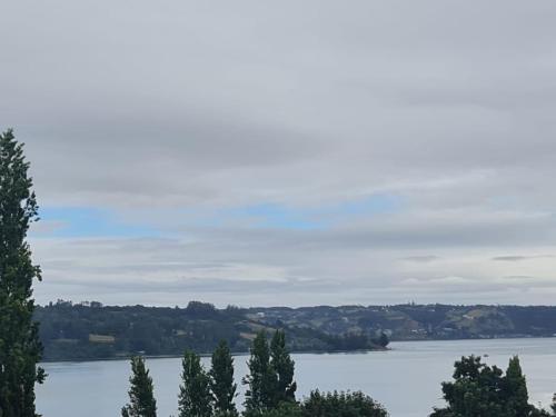 a view of a large body of water with trees at cabaña vista mágica in Castro