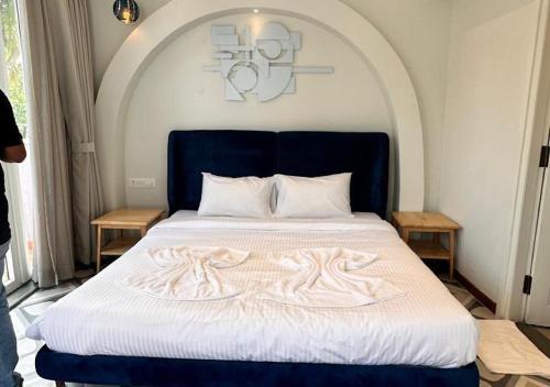 a bedroom with a bed with a blue headboard at VILLA M- SAVANNAH 7- 5BHK Brand New Villa in Calangute with Private Pool, Near Beach, free Breakfast, north goa in Goa