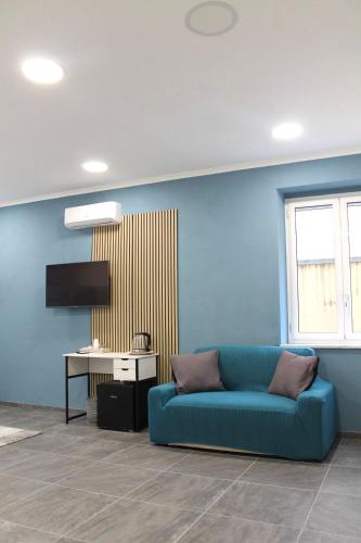 a living room with a blue couch and a table at Dimora Vannucchi in San Giorgio a Cremano
