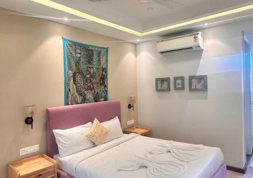 a bedroom with a bed and a painting on the wall at VILLA M- SAVANNAH 7- 5BHK Brand New Villa in Calangute with Private Pool, Near Beach, free Breakfast, north goa in Goa