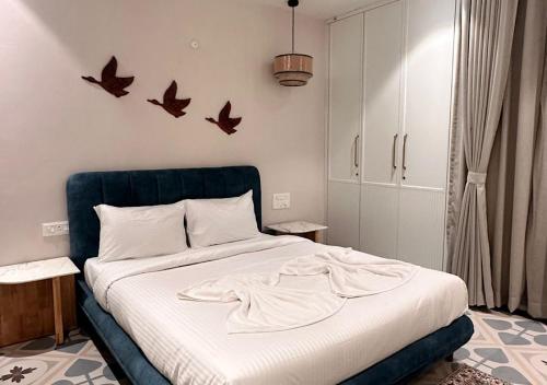 a bedroom with a bed with birds on the wall at VILLA M- SAVANNAH 7- 5BHK Brand New Villa in Calangute with Private Pool, Near Beach, free Breakfast, north goa in Goa