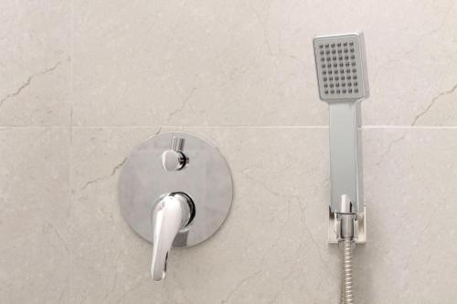 a shower head on a tiled bathroom wall at Dimora Vannucchi in San Giorgio a Cremano