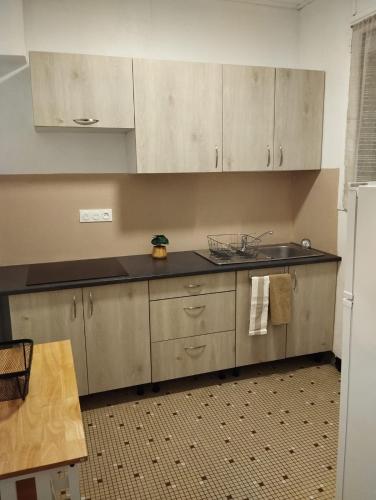 une cuisine avec des armoires blanches et un comptoir noir dans l'établissement Maison deux chambres avec jardin à 100m de l'océan, à Les Sables-dʼOlonne