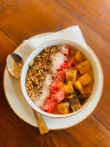 a bowl of food on a plate with a spoon at White Lion Paradise Dikwella in Batigama