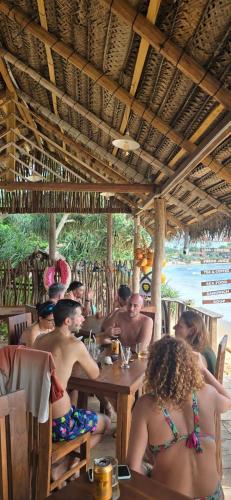 a group of people sitting at a table in a restaurant at White Lion Paradise Dikwella in Batigama