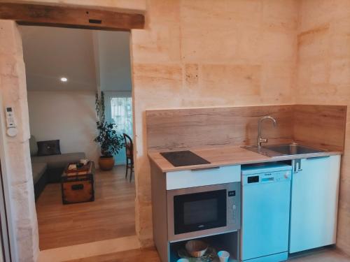 a kitchen with a sink and a counter top at Gîte Jardin Du Chay in Galgon