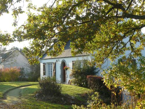 a small white house with a yard at A l'Ombre des Pommiers in Ergué-Gabéric
