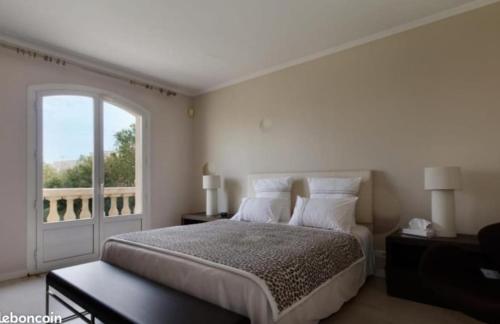 una camera da letto con un letto e una grande finestra di Rare Villa luxueuse 250 M2 proche plage Perols a Pérols