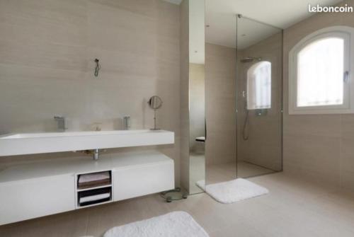 un bagno bianco con lavandino e doccia di Rare Villa luxueuse 250 M2 proche plage Perols a Pérols