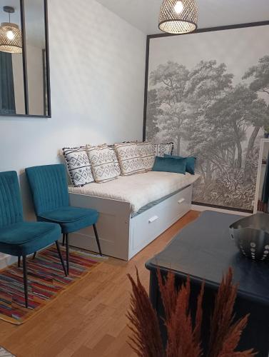 - un salon avec un canapé et deux fauteuils bleus dans l'établissement Studio Ault, à Ault