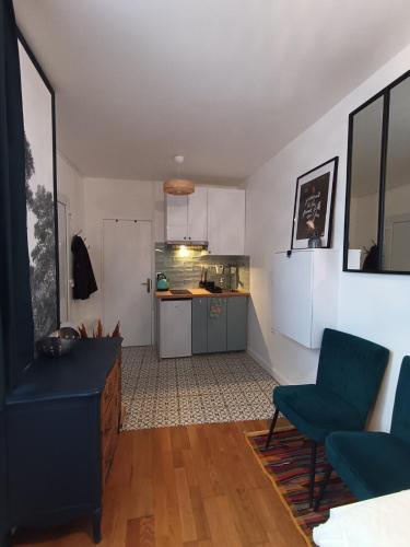 Il comprend un salon avec des chaises bleues et une cuisine. dans l'établissement Studio Ault, à Ault