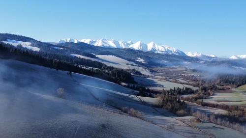 a view of a snowy mountain range with snow covered mountains at Dom Janosik in Kacwin
