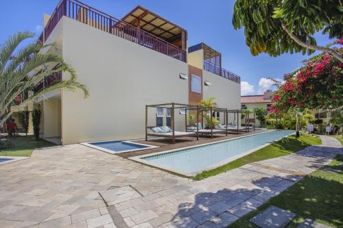 a swimming pool in front of a house at TRIPLEX Solar Água- by Pipa Praia House in Pipa
