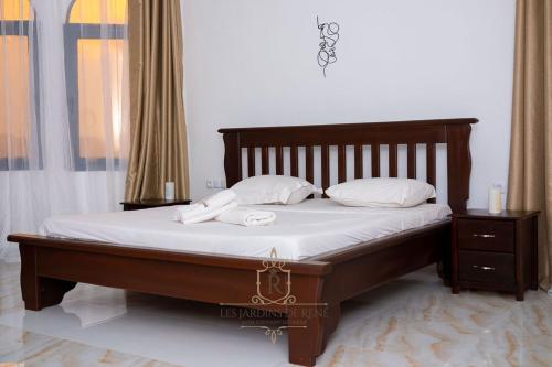 a bedroom with a bed with two towels on it at Les Jardins de René Hébergements in Yaoundé