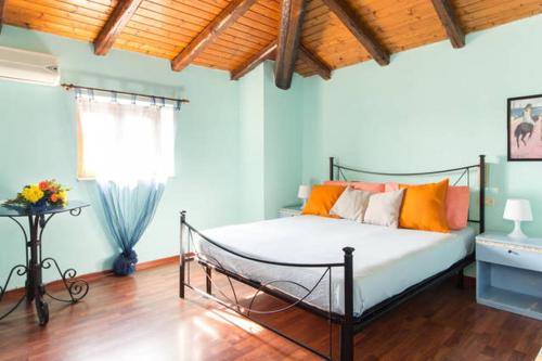 1 dormitorio con 1 cama con almohadas de color naranja y ventana en Casa Levante, en Siracusa