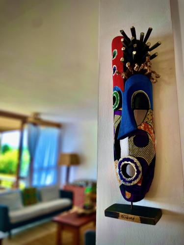 a vase is hanging on a wall in a living room at Casa do Mar in São Tomé