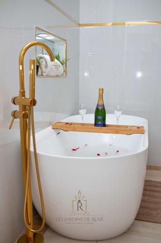 a bath tub with two wine glasses and a bottle at Les Jardins de René Hébergements in Yaoundé