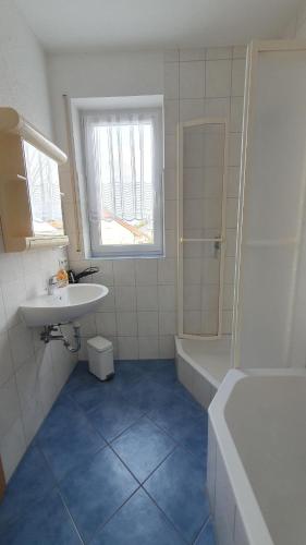 a bathroom with a sink and a tub and a toilet at Apartment Christa in Schwendi