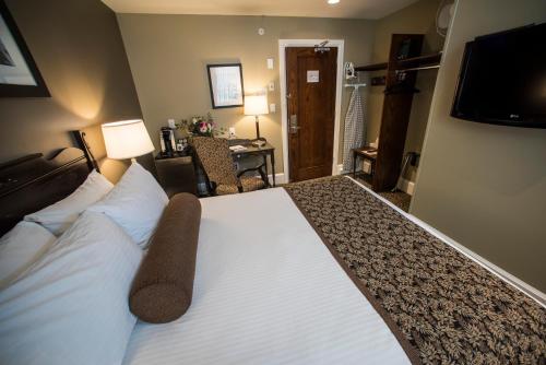 a hotel room with a large bed and a desk at Hume Hotel & Spa in Nelson